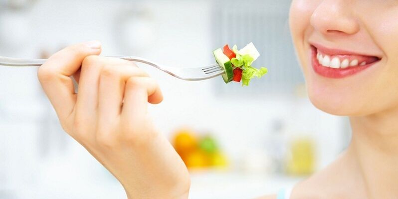 A rapaza come ensalada de verduras, perdendo peso na súa dieta favorita